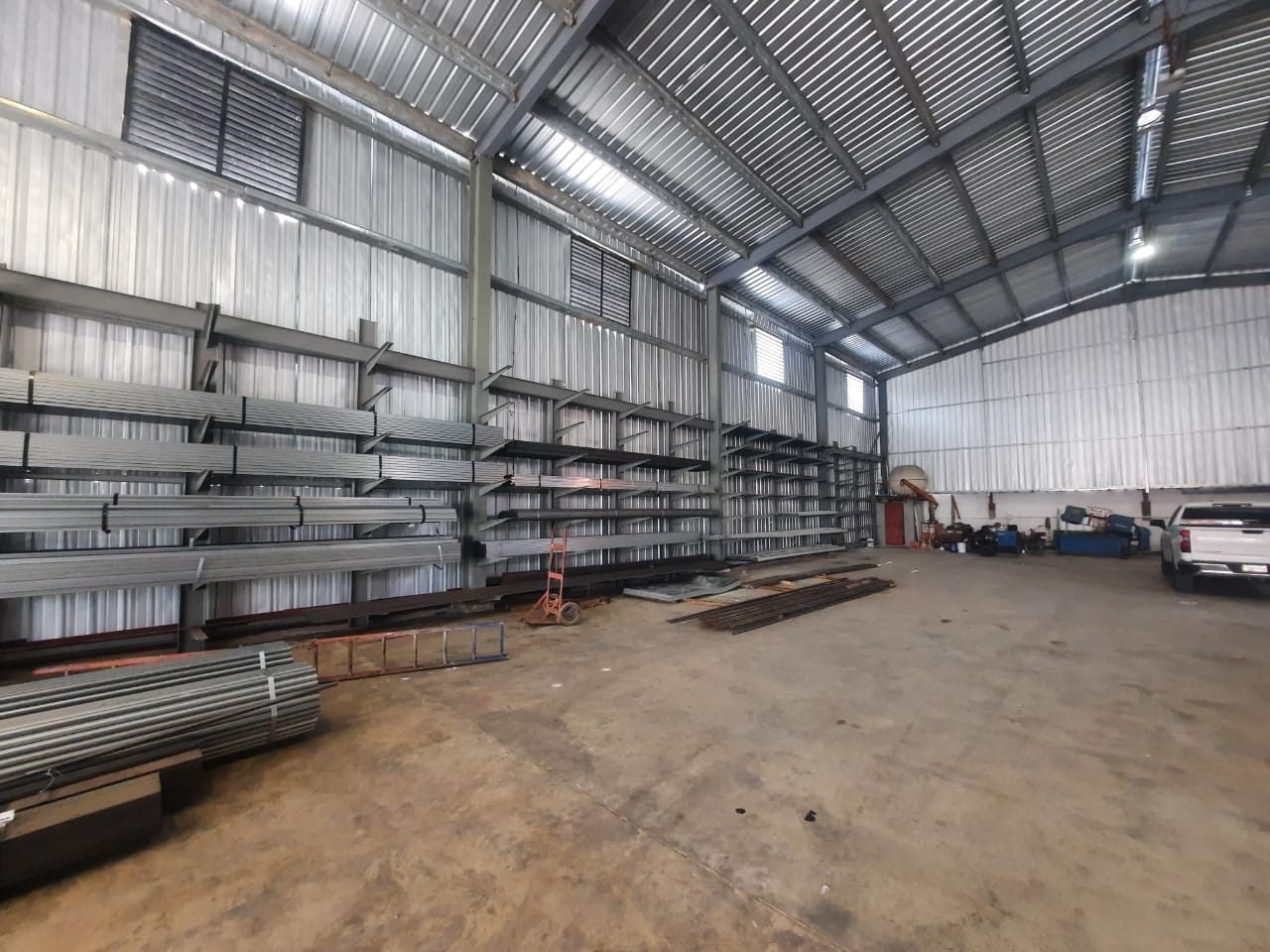 Interior de nuestra planta con perfiles y tubería de acero en racks